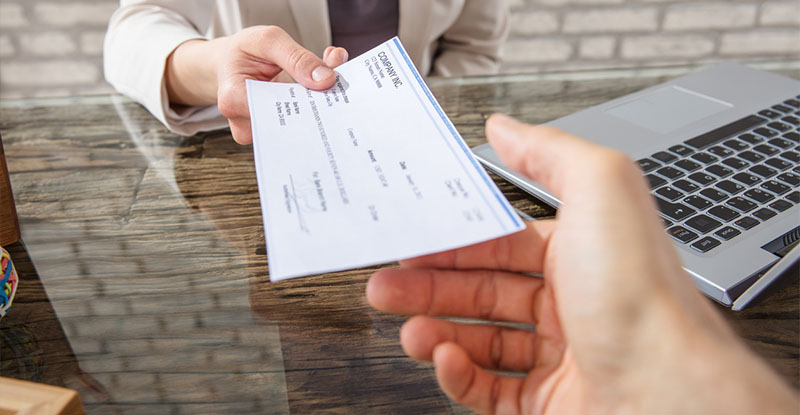 someone handing an expense check